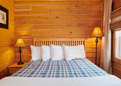 queen bed inside a wooden cabin