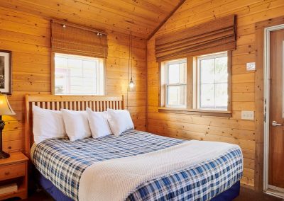 queen bed inside a wooden cabin