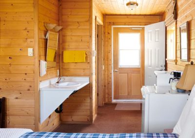 inside wooden cabin with sink, fridge. microwave. coffee maker